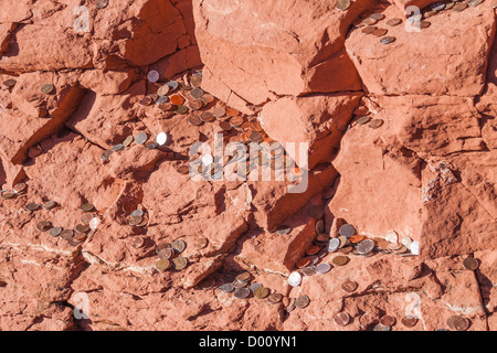 Münzen, die auf roten Felsen in der Kapelle des Heiligen Kreuzes in Sedona, Arizona geworfen wurden. Stockfoto