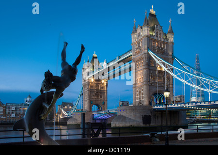 David Wynnes Mädchen mit einer Delfin-Statue unter der Tower Bridge, London England, UK Stockfoto