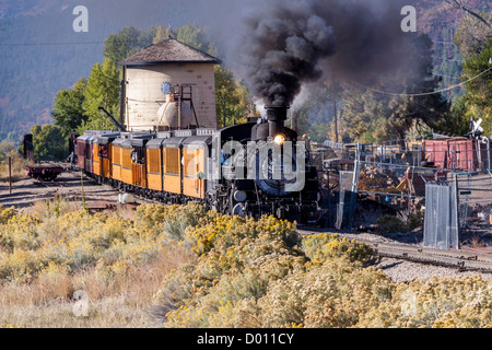 1925 Baldwin Dampflokomotive, 2-8-2 Konfiguration, Typ Mikado, vorbei am Wasserturm in Hermosa, Colorado, auf der D&SNG Railroad Route. Stockfoto