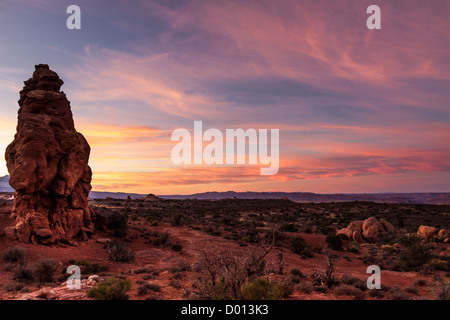 Auffällige Farben in den Wolken bei Sonnenaufgang über Sandstein-Formationen im Arches National Park in Utah. Stockfoto