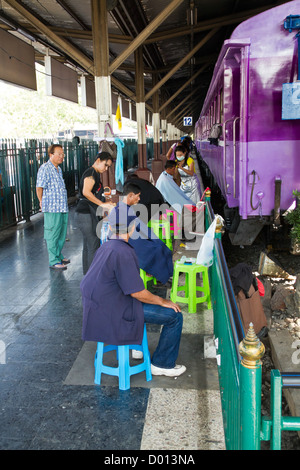 Haare schneiden auf einer Plattform von der Hauptbahnhof in Bangkok, Thailand Stockfoto