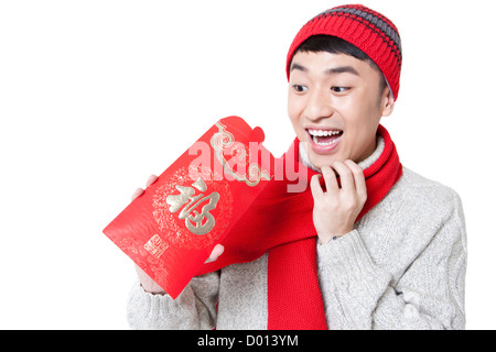 Amüsiert junger Mann in rot suchen umhüllen in Chinese New Year Stockfoto