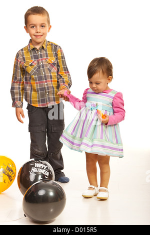 Wenige Kinder halten ihre Hände unter Halloween Ballons Stockfoto