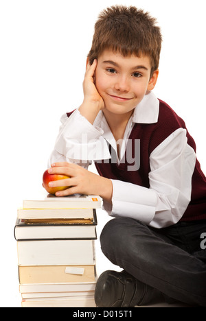 Lächelnd Student junge Holding Apfel und Hand auf Bücher, die isoliert auf weißem Hintergrund Stockfoto