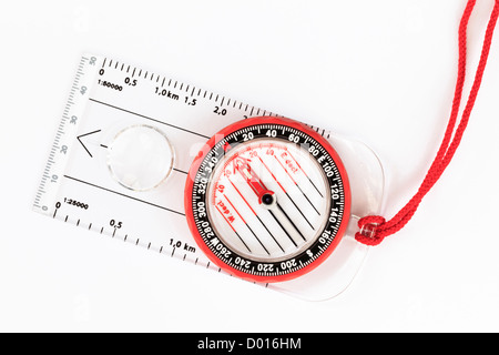 Nahaufnahme eines modernen OL Grundplatte Wandern Kompasses zeigt Nordrichtung für die Navigation mit roten Schlüsselband auf einem weißen Hintergrund von oben Stockfoto