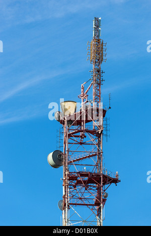 Fernmeldeturm mit Antennen über einen blauen Himmel. Stockfoto