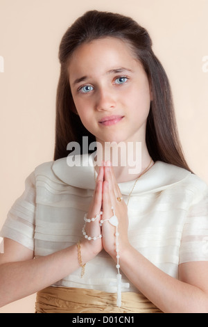 Hübsches Mädchen am Tag ihre Gemeinschaft im Gebet mit dem Rosenkranz in den Händen Stockfoto