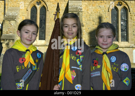 Drei brownies in Uniform tragen Mohn außerhalb der lokalen Kirche für Erinnerung Sonntag, Haslemere, Surrey, Großbritannien. Stockfoto