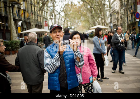 La Ramblas, Barcelona, Katalonien, Spanien. 14. November 2012. Japanische Touristen fotografieren einer Demonstration. Der Generalstreik in Spanien gegen wohl schneidet und Arbeitsreform verändert das Aussehen der Menge Rambla, das Hauptreiseziel in der Innenstadt von Barcelona. Bildnachweis: Jordi Boixareu / Alamy Live News Stockfoto