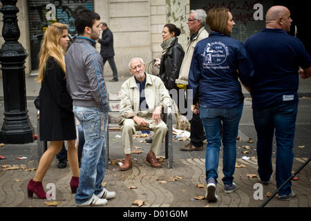 La Ramblas, Barcelona, Katalonien, Spanien. 14. November 2012. Ein Mann liegt inmitten Durchreisende. Der Generalstreik in Spanien gegen wohl schneidet und Arbeitsreform verändert das Aussehen der Menge Rambla, das Hauptreiseziel in der Innenstadt von Barcelona. Bildnachweis: Jordi Boixareu / Alamy Live News Stockfoto