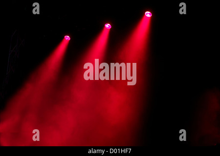 Wellen von farbigen Farblicht glänzen durch atmosphärische Rauch auf dramatische Weise auf eine leere Bühne Licht Stockfoto