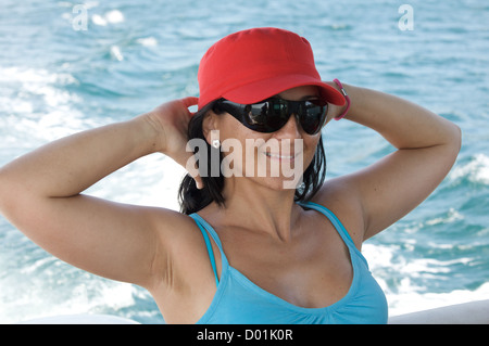 Glückliches Mädchen im Urlaub auf See mit Sonnenbrille Stockfoto