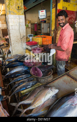 Lächelnd Mann arbeitet an einem Fisch stand, Polakandam Markt, Kochi (Cochin), Indien Stockfoto