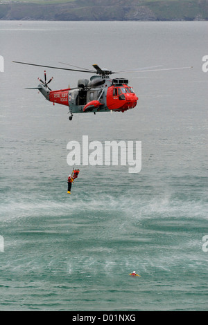 Eine gerettete Person wurde während einer Rettungsübung vor Newquay zu einem Such- und Rettungshubschrauber von RNAS Culdrose in Cornwall, SW England, gebracht Stockfoto