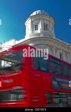 Ein roten Doppeldecker-Bus geht das reich verzierte Coronet-Kino in Notting Hill Gate Stockfoto