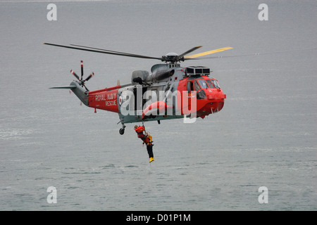 Eine gerettete Person wurde während einer Rettungsübung vor Newquay zu einem Such- und Rettungshubschrauber von RNAS Culdrose in Cornwall, SW England, gebracht Stockfoto