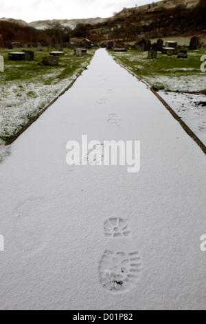 Fußabdrücke sichtbar auf eine lange Schnee fallen weg. Stockfoto