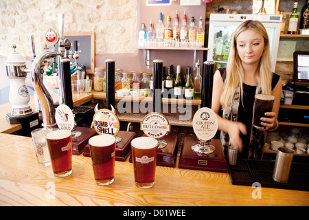 Eine blonde Bardame serviert Pints Bier im Gasthaus Griffin, Bad Somerset UK Stockfoto