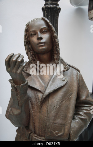 Eine Frau lehnte sich gegen einen Laternenpfahl, einer der mehrere Bronze-Skulpturen rund um die Altstadt, Bratislava, Slowakei. Stockfoto