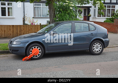 Orange-Rad Klammer auf ein Bue-Auto auf der Straße Stockfoto