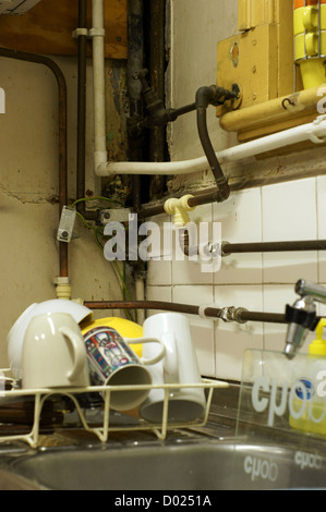 Alte Küche Rohre mit einige Gerichte auf einer Abtropffläche und ein Waschbecken Stockfoto