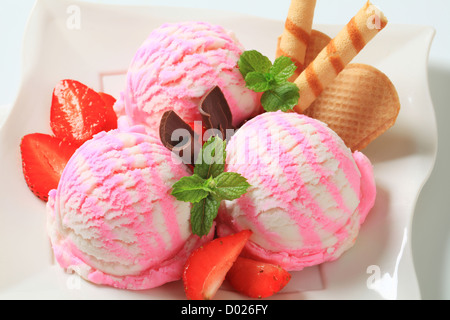 Eisbecher mit Erdbeeren und Waffelröllchen Stockfoto