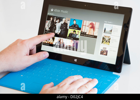 Mann mit Microsoft Surface rt Tablettcomputer Musik im Store durchsuchen Stockfoto