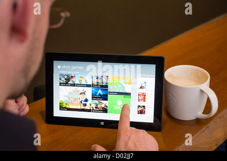 Mann mit Microsoft Surface rt Tablettcomputer Spiele im AppStore durchsuchen Stockfoto