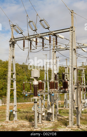 Teil der Hochspannungsstation Anschlüsse gegen Himmel und Wald Stockfoto