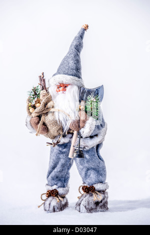 Santa Claus im Winterschnee spazieren und eine großes Geschenk-Tasche in seinen Armen hält. Stockfoto