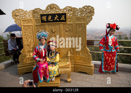 Chinesische Touristen posieren für Fotos tragen traditionellen Kleidung auf einer Promenade oberhalb der verbotenen Stadt, Peking, China. Stockfoto