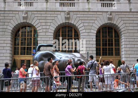 Touristen Line-up, Fotografieren mit der Wall Street Bull untere Manhattan New York City lassen Stockfoto