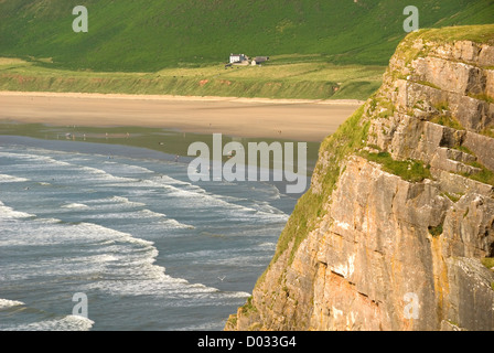 Steilen Felsen, brechen Wellen und Menschen an Rhossili Strand, Gower Halbinsel, Wales, UK Stockfoto