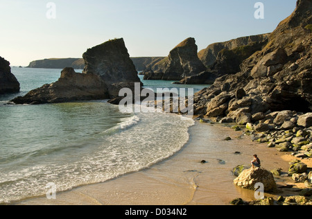 Bedruthan Schritte Beach, Frau sitzt auf einem Felsen, North Cornwall, England, UK Stockfoto