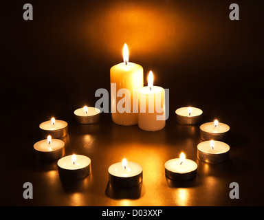 Brennende Kerzen auf dunklem Hintergrund Stockfoto