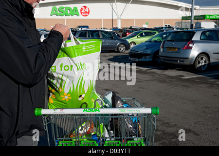 Nahaufnahme von Mann Person mit tragen ASDA Supermarkt einkaufen Taschen in Trolley England Vereinigtes Königreich GB Großbritannien Stockfoto