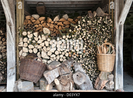 Brennholz gestapelt und bereit für den Winter, Wales, UK Stockfoto