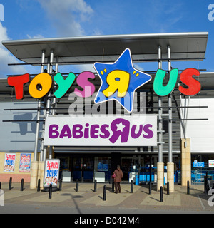 Frau, die in Richtung Eingang zum Geschäft „Toys R US“ geht, in dem sich die Ladengeschäfte „Babies R US“ im Lakeside Retail Park West Thurrock UK befinden Stockfoto