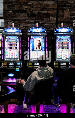 Männer sitzen an Spielautomaten im Foxwoods Resort Casino, Ledyard, Connecticut, USA Stockfoto