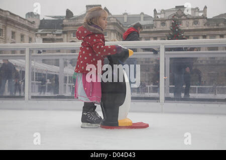 16. November 2012. London UK. Kinder lernen mit Hilfe eines Pinguins auf dem Eis Schlittschuh laufen, als Somerset House verwandelt ihren Garten in eine Eisbahn für den Winter für die Öffentlichkeit zugänglich ist Stockfoto