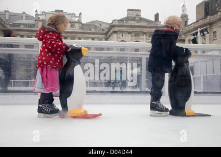 London, UK. 16. November 2012. Kinder lernen, mit Hilfe eines Pinguins auf dem Eis Schlittschuh laufen, als Somerset House verwandelt ihren Garten in eine Eisbahn für den Winter für die Öffentlichkeit zugänglich ist. Bildnachweis: Amer Ghazzal / Alamy Live News Stockfoto