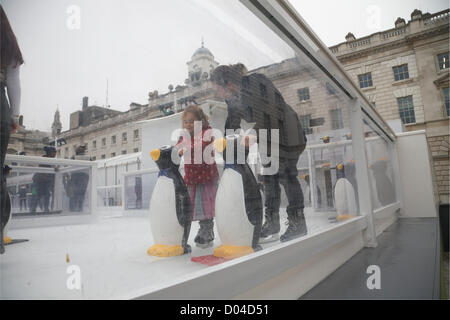 London, UK. 16. November 2012. Eltern unterstützen ihre Kinder lernen mit Hilfe eines Pinguins auf dem Eis Schlittschuh laufen, als Somerset House verwandelt ihren Garten in eine Eisbahn für den Winter für die Öffentlichkeit zugänglich ist. Bildnachweis: Amer Ghazzal / Alamy Live News Stockfoto