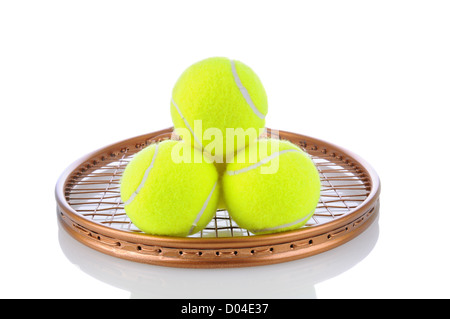 Nahaufnahme eines Stapels von Tennisbällen auf den Saiten eines Schlägers. Querformat auf einem weißen Hintergrund mit Reflexion. Stockfoto