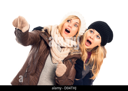 Zwei Mädchen schockiert in Winterkleidung zeigen, isoliert auf weißem Hintergrund. Stockfoto