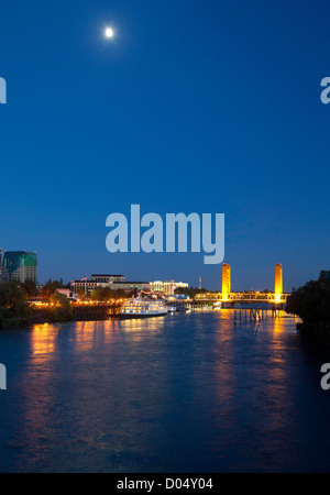 Blick auf die Skyline der Stadt Sacramento in der Abenddämmerung, einschließlich Stadtzentrum gelegene Gebäude, das Delta King River Boot und die Tower Bridge. Stockfoto