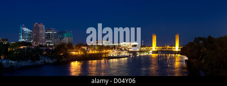Panorama auf die Skyline der Stadt Sacramento in der Abenddämmerung, einschließlich Stadtzentrum gelegene Gebäude, das Delta King River-Boot und die Tower Bridge. Stockfoto