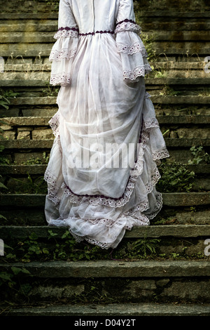 eine Frau in einem Hochzeitskleid ist alte steinerne Treppe hinauf wandern. Stockfoto