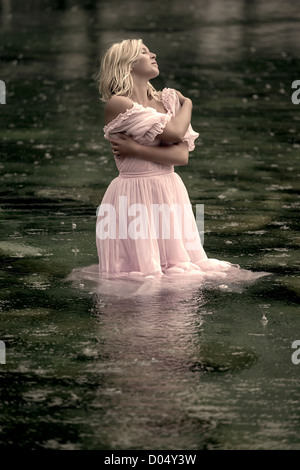 eine Frau im Wasser stehn und genießen den Regen Stockfoto