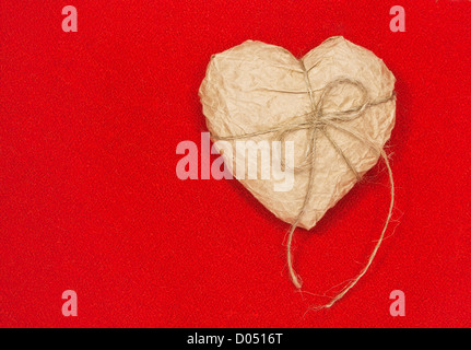 Papierherz auf rotem Grund. Konzept. Stockfoto