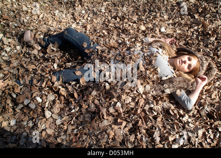 Frau begraben in Eiche Blätter Stockfoto